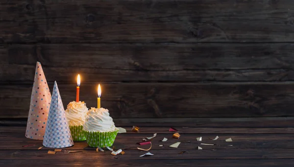古い暗い背景の木の上のろうそくの誕生日カップケーキ — ストック写真