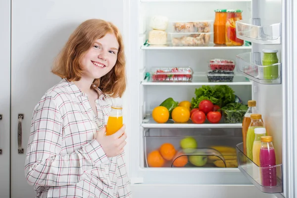 Tiener meisje bij koelkast met voedsel — Stockfoto