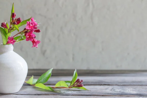 Roze zomer bloemen in witte vaas op houten tafel — Stockfoto