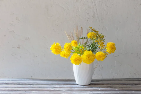 Sárga nyári virágok a kancsó fehér alapon — Stock Fotó