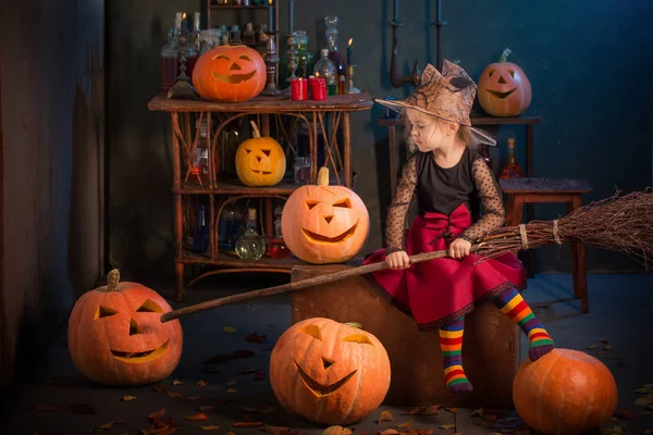 Little witch with Halloween pumpkins indoor — Stock Photo, Image