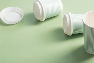 yeşil arka plan üzerinde kahve ile tek kullanımlık kağıt fincan