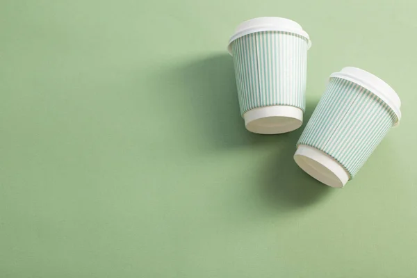 Taza de papel desechable con café sobre fondo verde — Foto de Stock