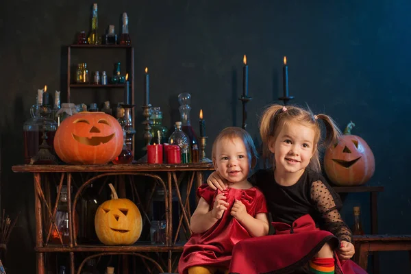 Duas bruxinhas com abóboras de Halloween indoor — Fotografia de Stock
