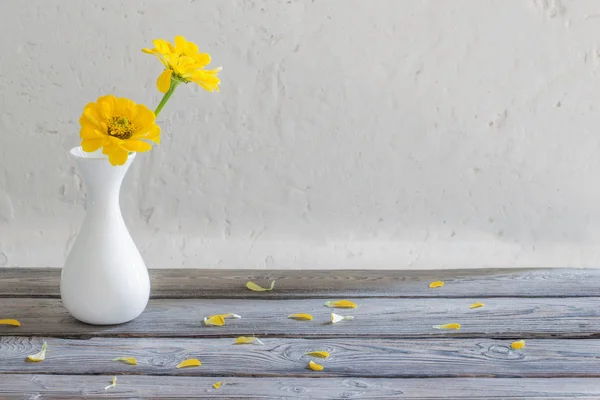 Zinnia amarela em vaso branco na mesa de madeira — Fotografia de Stock