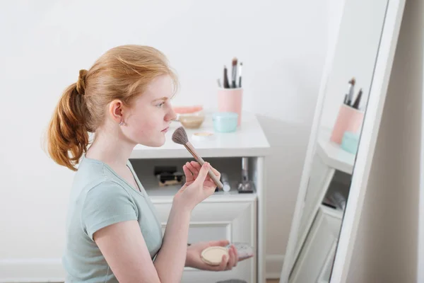 Tiener meisje poeders haar gezicht — Stockfoto