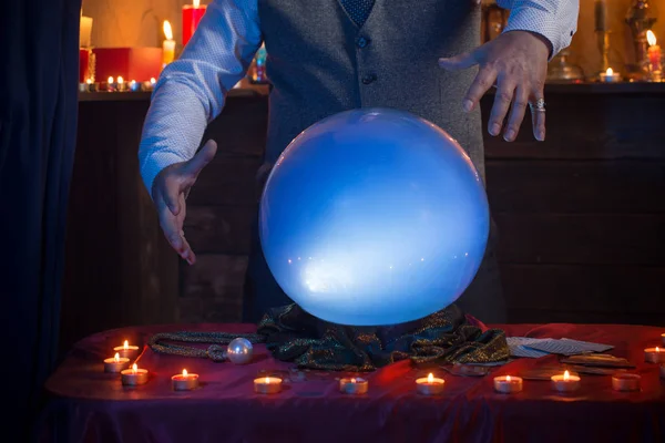 Hands of fortune teller with illuminated crystal ball — Stock Photo, Image