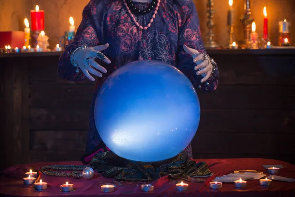 Mãos de cartomante com bola de cristal iluminada — Fotografia de Stock