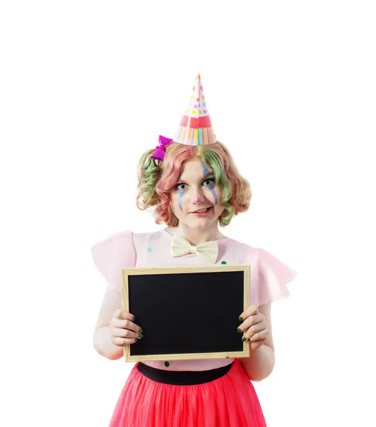 Glimlach tiener meisje in clown kostuum met schrijfbord geïsoleerd — Stockfoto