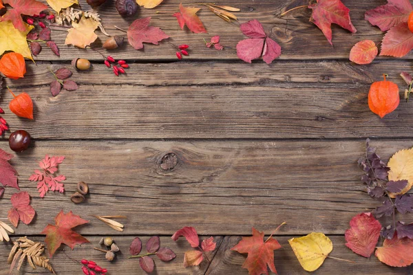 Autumn leaves on darrk old wooden background — Stock Photo, Image