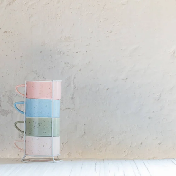 Сучасні керамічні чашки на фоні білої стіни — стокове фото