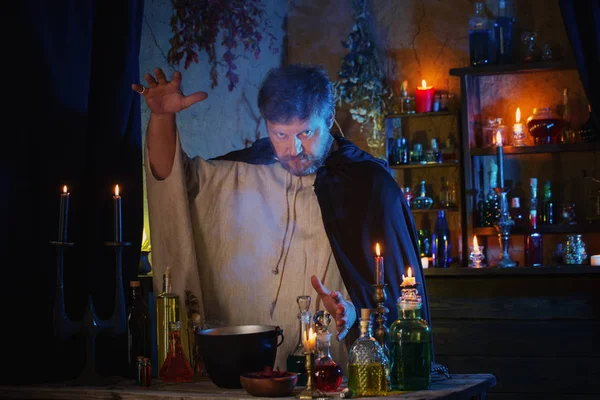 Portrait of  wizard with burning candles and magic potions — Stock Photo, Image