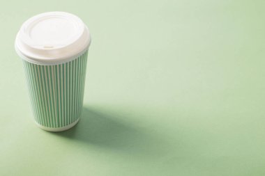 yeşil arka plan üzerinde kahve ile tek kullanımlık kağıt fincan