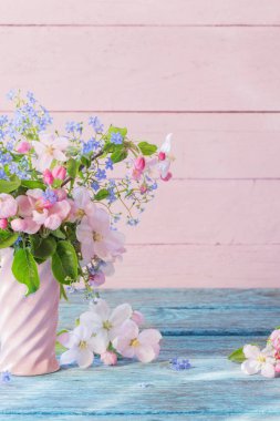 Tahta arka planda vazoda bahar çiçekleri