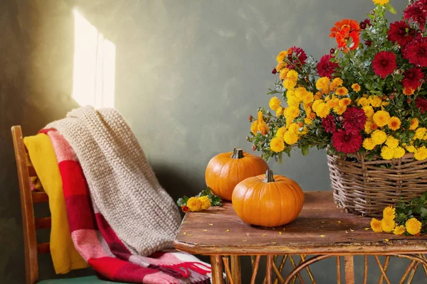 Still life with chrysanthemums in basket and pumpkins on wooden — Stock Photo, Image