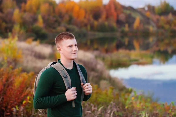 Ung turist med ryggsäck nära höstsjön — Stockfoto