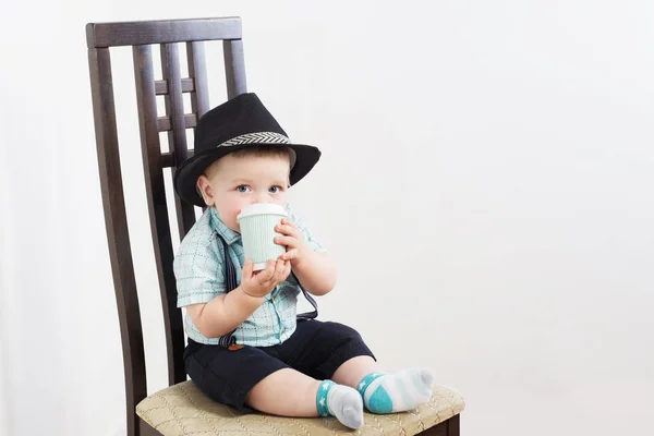 Kleine heer met hoed zit op stoel — Stockfoto