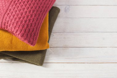 beyaz ahşap masa üzerinde kazak yığını