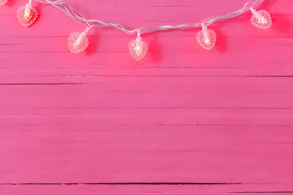 Guirnalda en forma de corazón sobre fondo de madera rosa — Foto de Stock