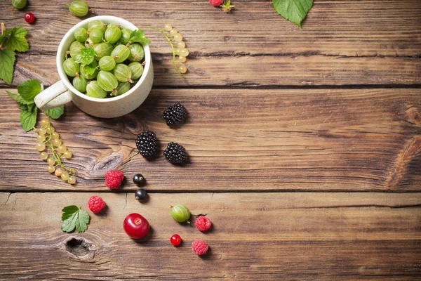 Verschiedene Beeren auf altem Holzgrund — Stockfoto