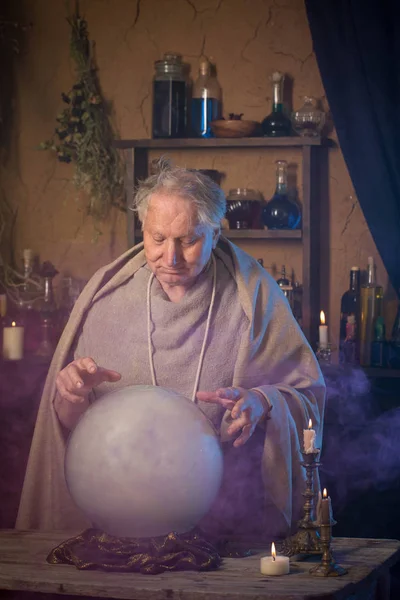 Anciano mago con bola de cristal — Foto de Stock