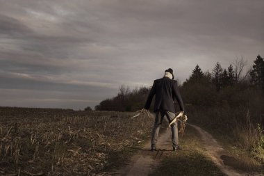 Korkuluk sonbahar tarlasında duruyor akşam gökyüzüne karşı