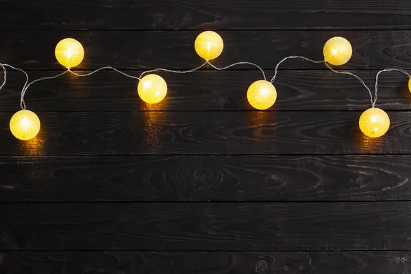 Weihnachten goldene Lichter auf dunklem Holzhintergrund — Stockfoto