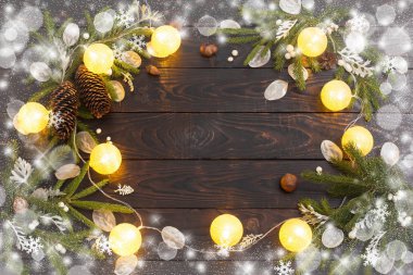 Karanlık ahşap arka planda ışıkları olan Noel süslemeleri.