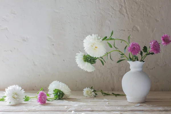 Aster y crisantemos en jarrón sobre mesa de madera blanca —  Fotos de Stock