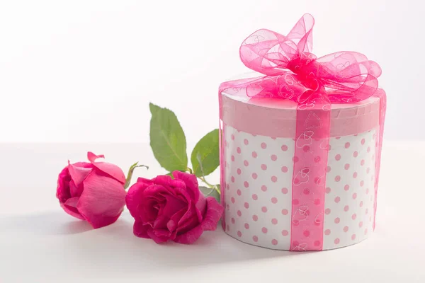 Beyaz arka planda pembe güller olan hediye kutusu — Stok fotoğraf