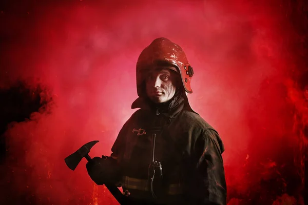 Egyenruhás tűzoltó portréja sötétvörös háttérrel — Stock Fotó