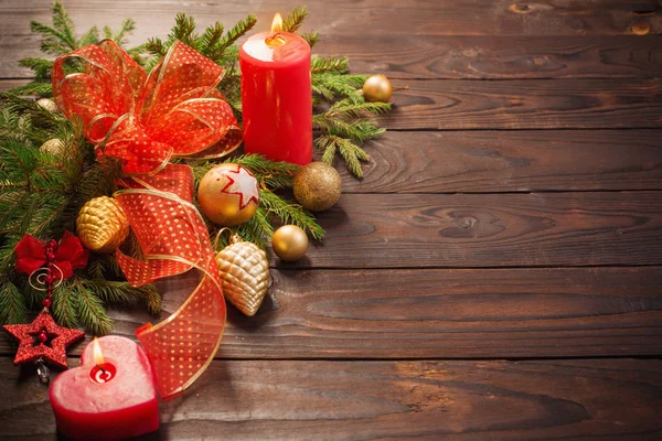 Rote und goldene Weihnachtsdekoration mit brennender Kerze auf Holz — Stockfoto