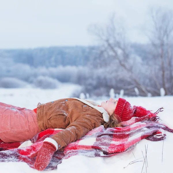 Teenie-Mädchen auf Plaid im Schnee — Stockfoto