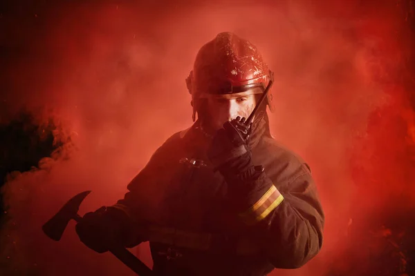 Retrato de bombero en uniforme sobre fondo rojo oscuro —  Fotos de Stock