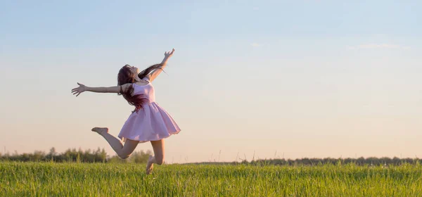 Hermosa Joven Vestido Rosa Saltando Campo —  Fotos de Stock