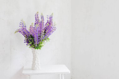 Beyaz vazodaki çiçekler beyaz mahsul iç kısımlarda