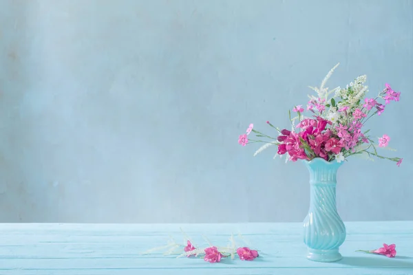 蓝色底色蓝色花瓶中的粉红花朵 — 图库照片