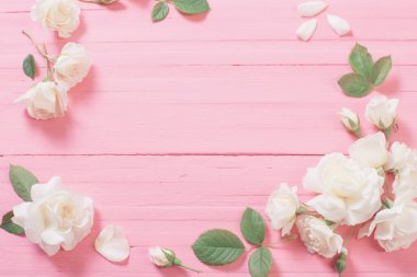 Beyaz güller pembe ahşap arka planda