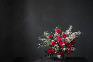 Arkadaki siyah duvarda kırmızı güller.