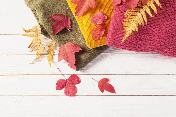 Stapel Pullover Mit Herbstblättern Auf Weißem Holztisch — Stockfoto