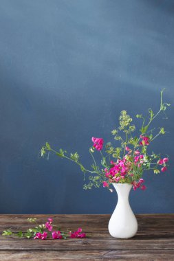 Pembe yaz çiçekleri ahşap masa üzerinde koyu arkaplan