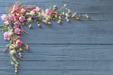 Koyu mavi ahşap arka planda güzel yaz çiçekleri