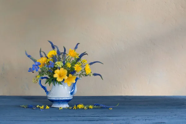 Ramo Con Flores Azules Amarillas Tetera Sobre Mesa Madera —  Fotos de Stock