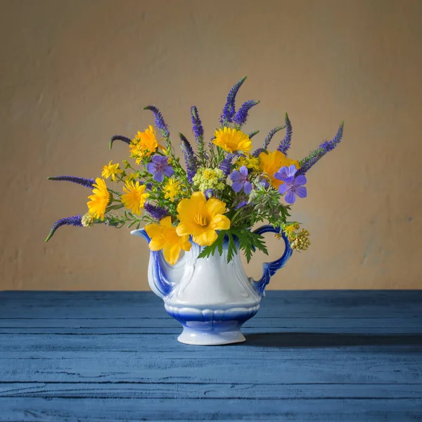 Ramo Con Flores Azules Amarillas Tetera Sobre Mesa Madera — Foto de Stock