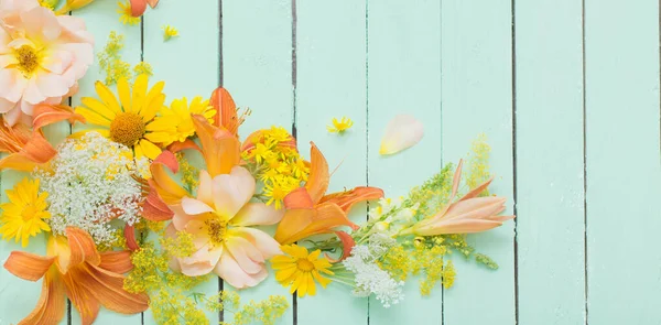 yellow and orange flowers on green wooden background