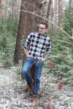 Genç adam kış ormanında