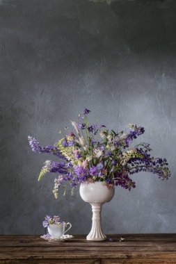 koyu arkaplanda mavi ve mor renkte yaz buketi