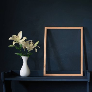 Vazodaki çiçekler ve arka plandaki ahşap çerçeve.