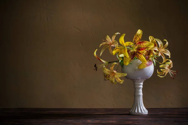 木制桌子上陶瓷白色花瓶里的黄色百合 — 图库照片