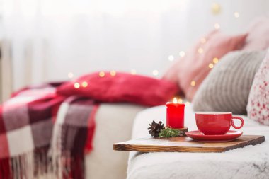 Evde yanan mumlarla bir fincan çay.